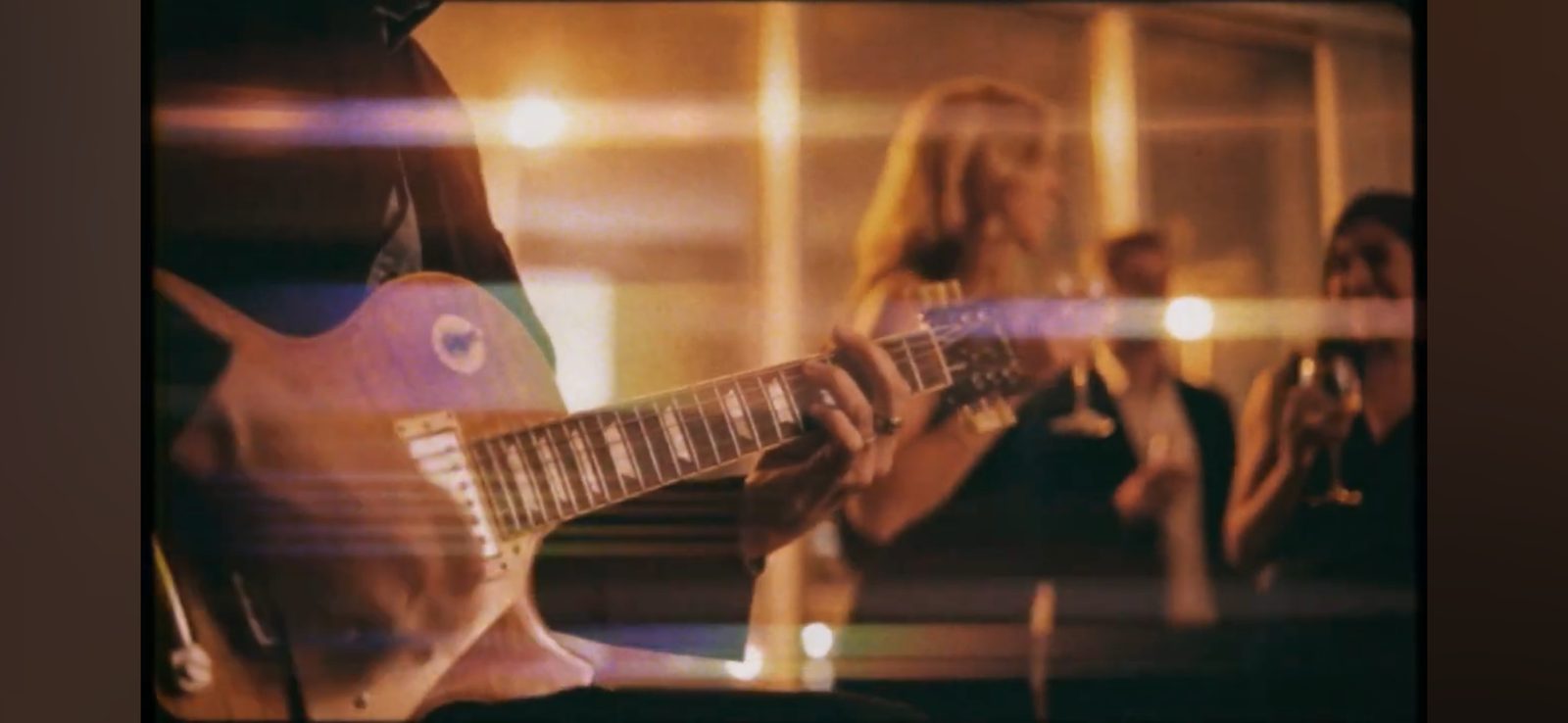 A guitarist playing — film grain, golden light